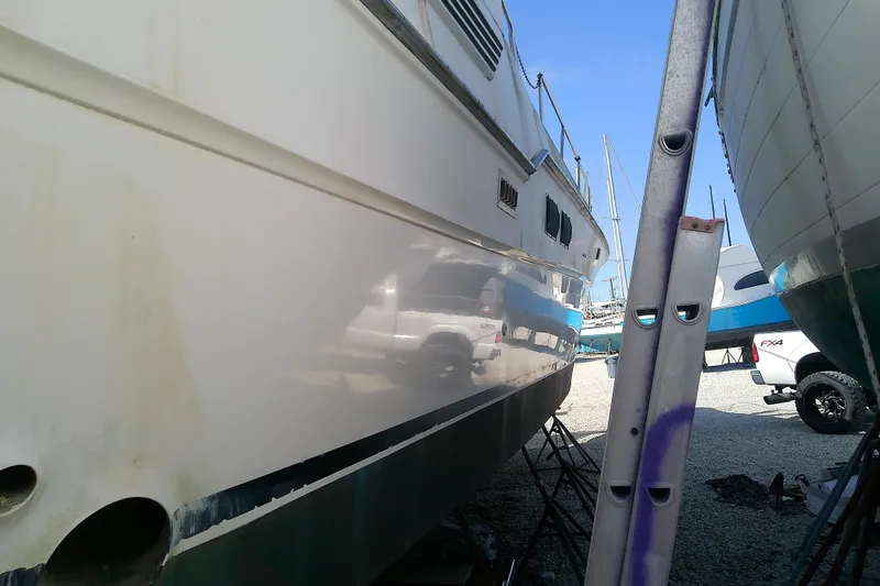 Slide: The Image of 1989 Sea Ray 440 Aft Cabin yacht on dry dock, side view with ladder. - 10
