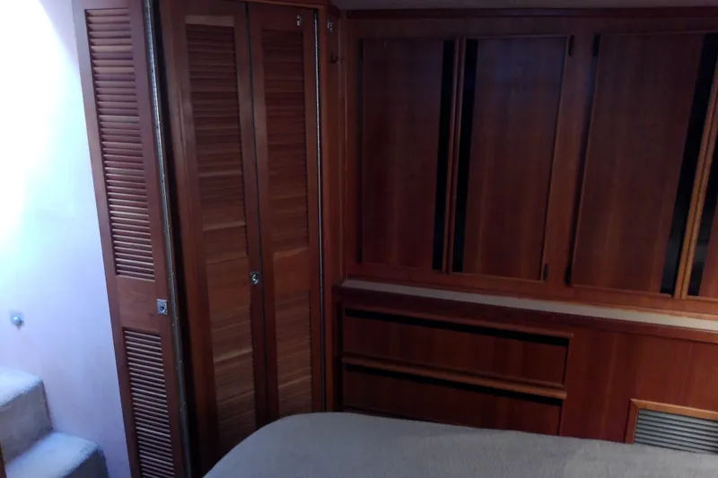 Slide: The Image of 1989 Sea Ray 440 Aft Cabin interior with wooden cabinetry and carpeted stairs. - 50