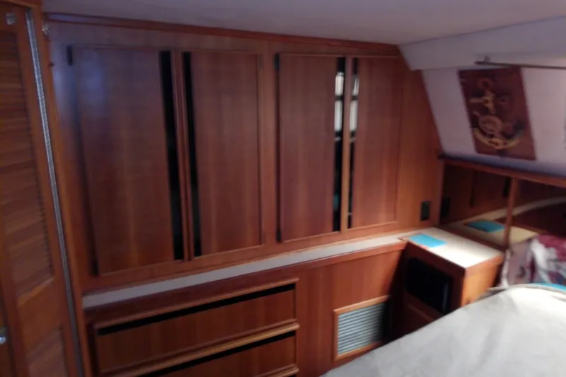 Slide: The Image of Interior of 1989 Sea Ray 440 Aft Cabin with wooden cabinetry and cozy decor. - 49