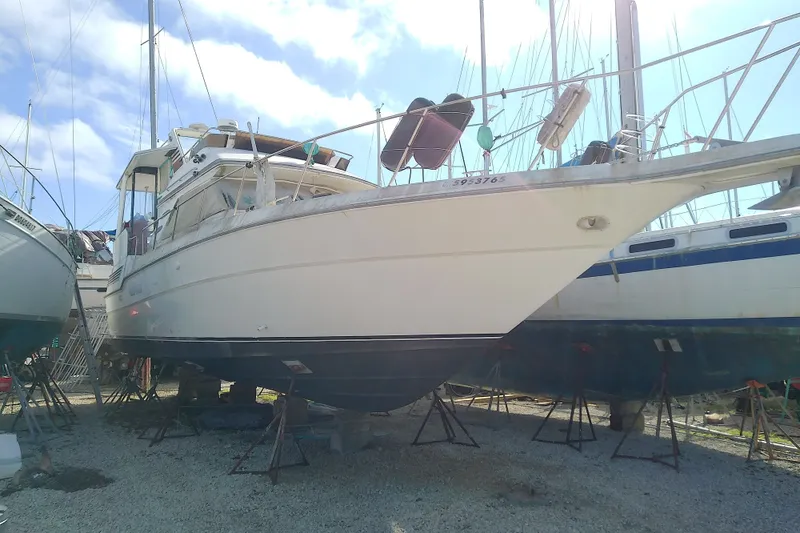Slide: The Image of 1989 Sea Ray 440 Aft Cabin yacht on dry dock under clear blue sky. - 1