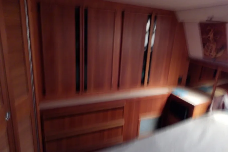 Slide: The Image of Interior of 1989 Sea Ray 440 Aft Cabin with wooden cabinetry and cozy design. - 46