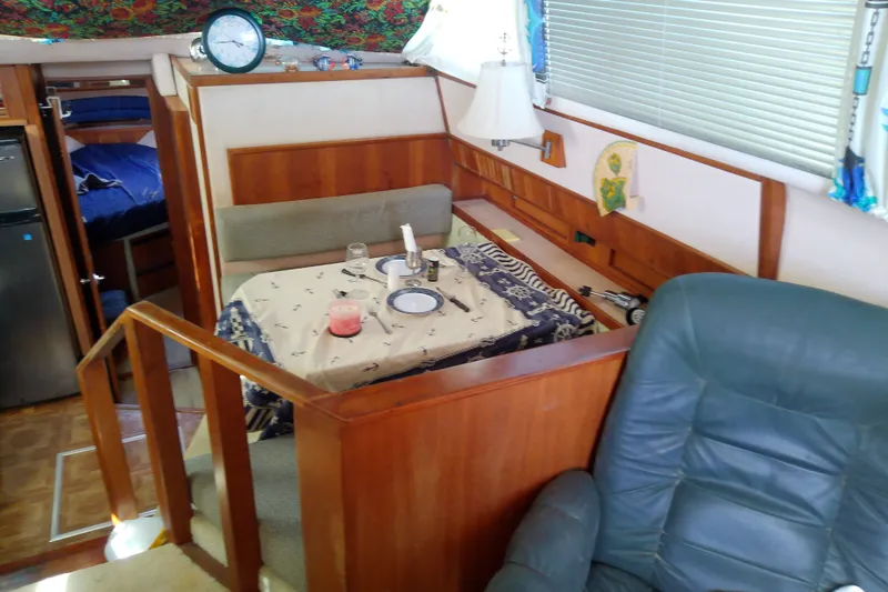 Slide: The Image of Interior of 1989 Sea Ray 440 Aft Cabin with dining area and seating. - 25