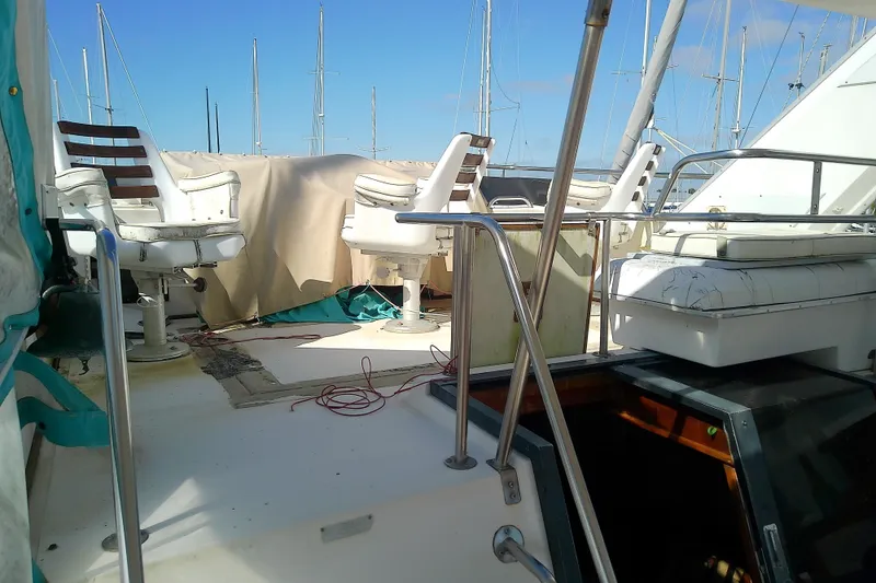 Slide: The Image of 1989 Sea Ray 440 Aft Cabin yacht deck with seating and railing, docked at marina. - 13