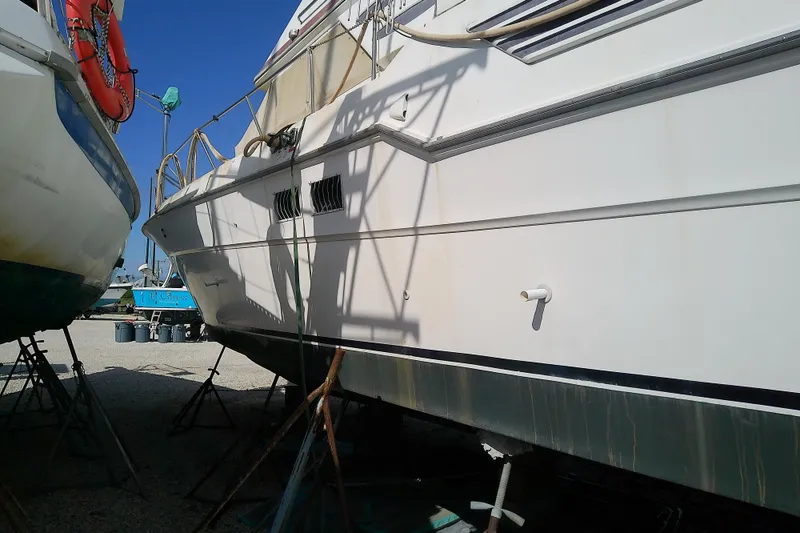 Slide: The Image of 1989 Sea Ray 440 Aft Cabin yacht on stands, side view in boatyard. - 5