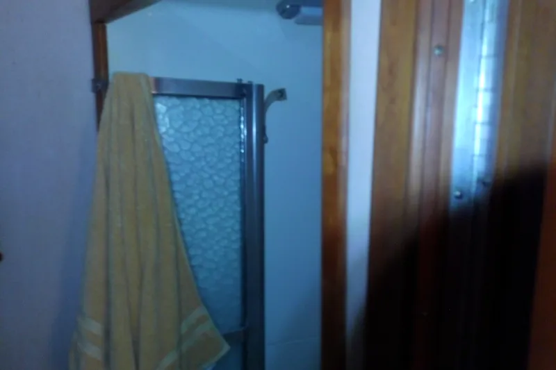 Slide: The Image of Shower area in 1989 Sea Ray 440 Aft Cabin with yellow towel hanging. - 53