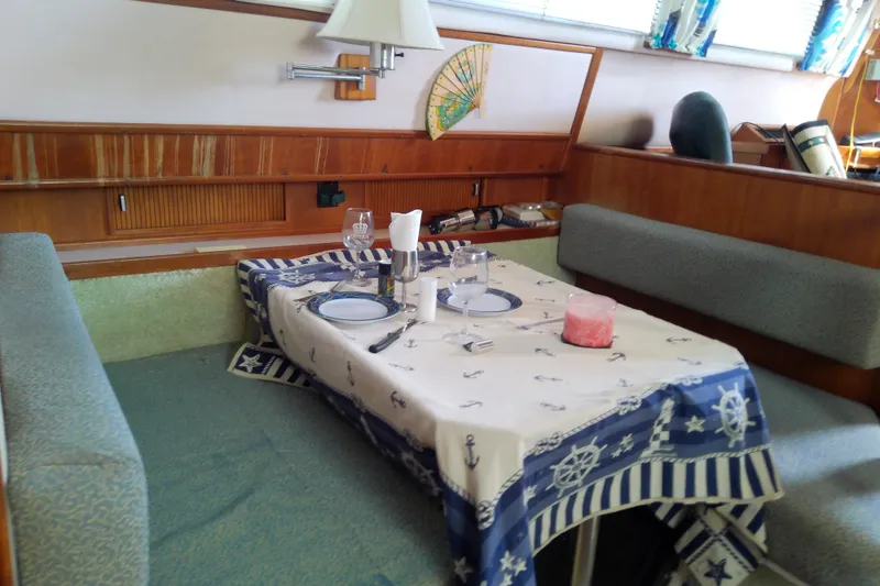 Slide: The Image of Dining area inside 1989 Sea Ray 440 Aft Cabin with nautical-themed table setting. - 34