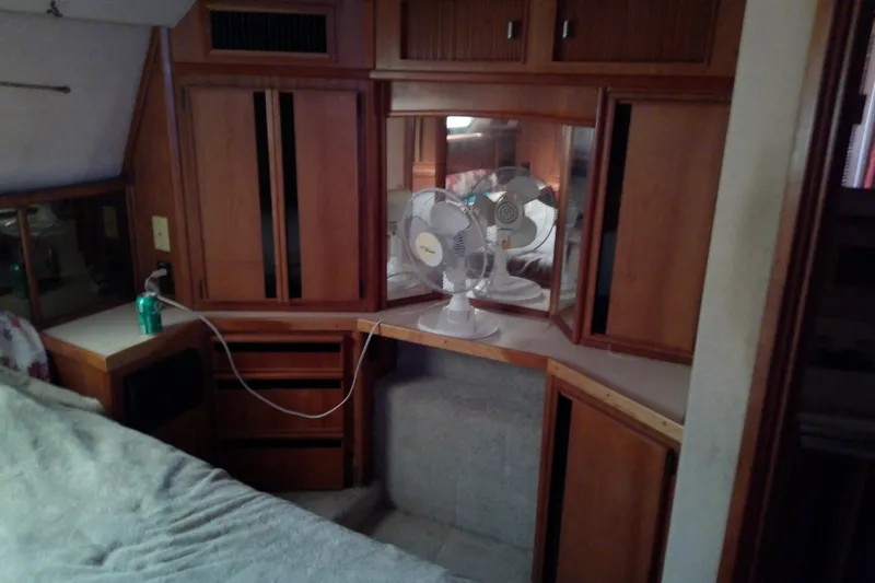 Slide: The Image of 1989 Sea Ray 440 Aft Cabin interior with wood cabinetry and fans. - 45