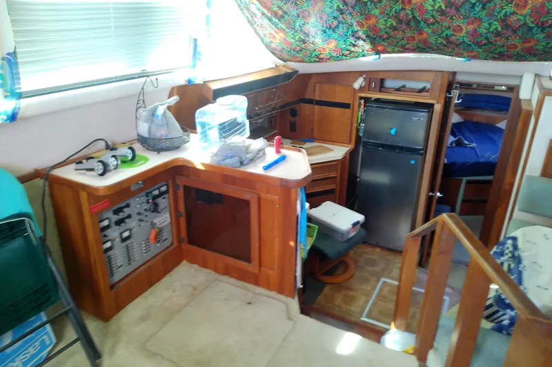Slide: The Image of 1989 Sea Ray 440 Aft Cabin interior with kitchen, fridge, and control panel. - 24