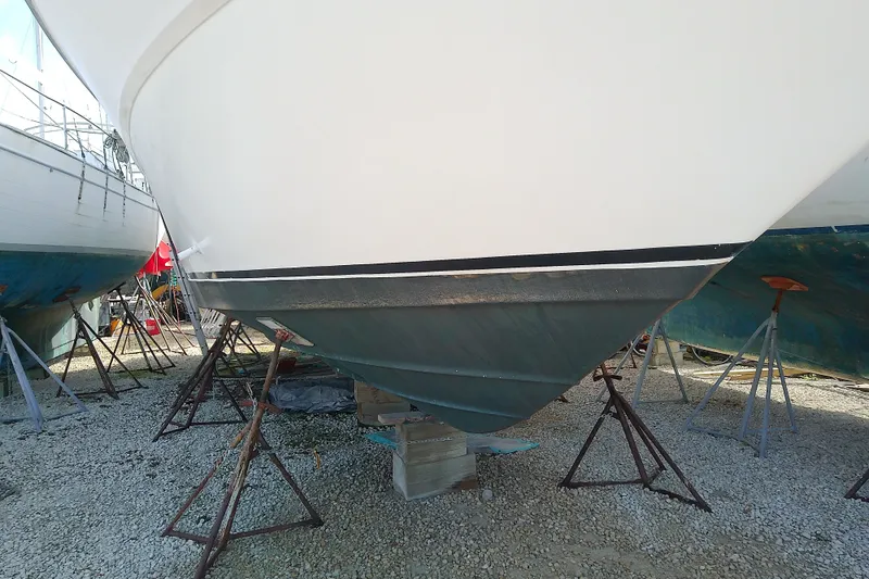 Slide: The Image of 1989 Sea Ray 440 Aft Cabin boat on stands, hull view, in a boatyard. - 2