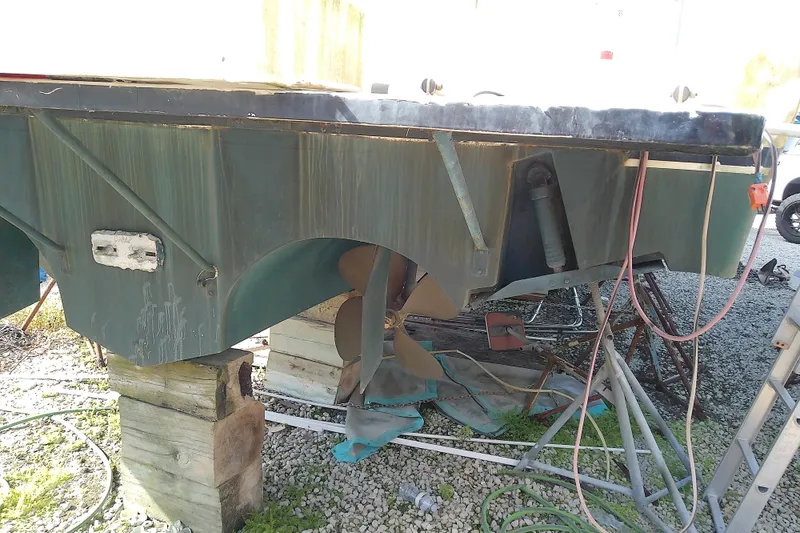 Slide: The Image of 1989 Sea Ray 440 Aft Cabin boat hull on blocks, showing propeller and rudder. - 9