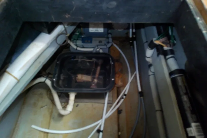 Slide: The Image of Bilge area of 1989 Sea Ray 440 Aft Cabin with visible wiring and plumbing. - 58