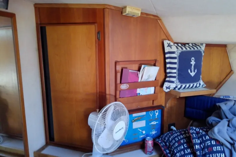 Slide: The Image of 1989 Sea Ray 440 Aft Cabin interior with nautical decor and wooden cabinetry. - 41