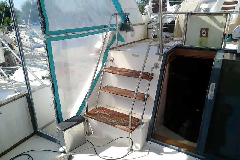 Slide: The Image of 1989 Sea Ray 440 Aft Cabin yacht with wooden steps and outdoor seating area. - 12
