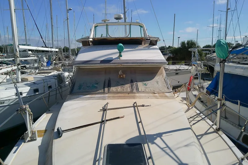 Slide: The Image of 1989 Sea Ray 440 Aft Cabin yacht docked among sailboats under clear blue sky. - 20