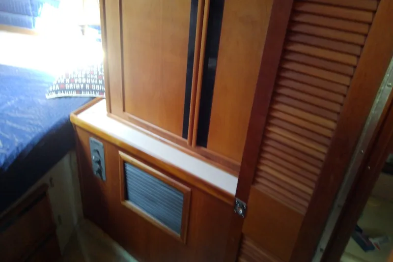 Slide: The Image of 1989 Sea Ray 440 Aft Cabin interior with wooden cabinetry and bed. - 39