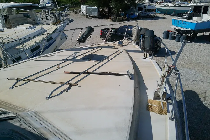 Slide: The Image of 1989 Sea Ray 440 Aft Cabin yacht on dry dock, surrounded by other boats. - 18