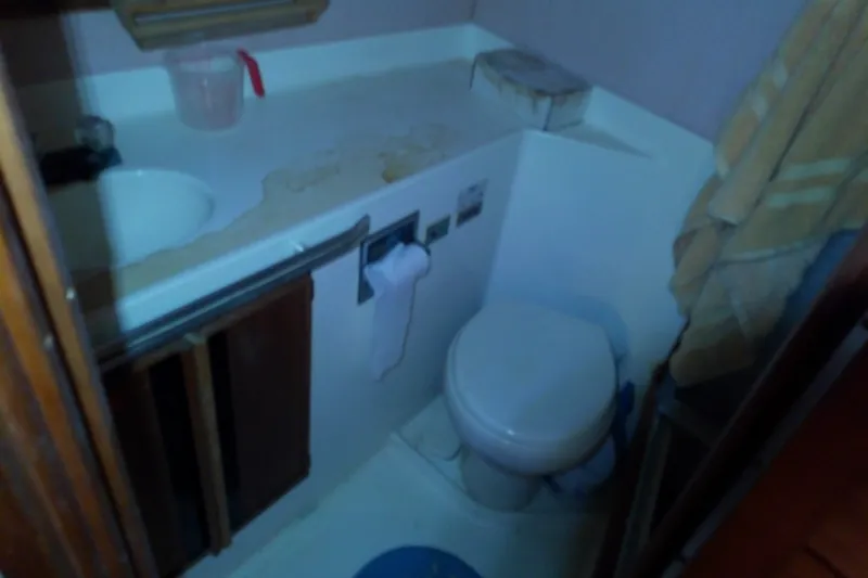 Slide: The Image of 1989 Sea Ray 440 Aft Cabin bathroom with sink, toilet, and storage cabinets. - 51