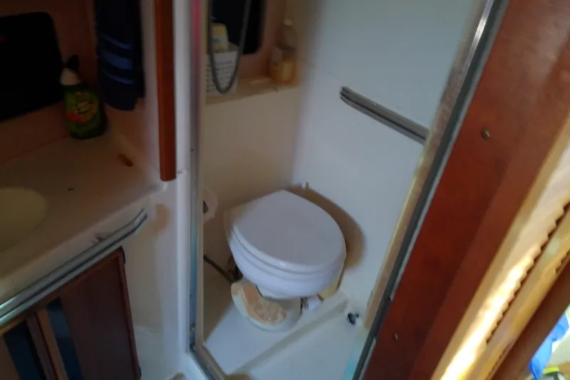 Slide: The Image of 1989 Sea Ray 440 Aft Cabin bathroom with toilet and sink area. - 36