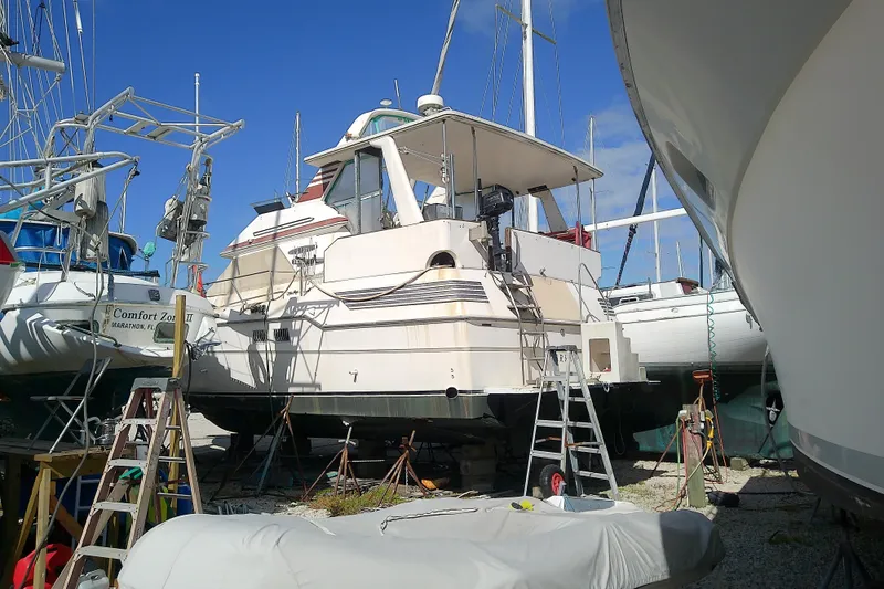 Slide: The Image of 1989 Sea Ray 440 Aft Cabin yacht in dry dock, surrounded by other boats. - 6