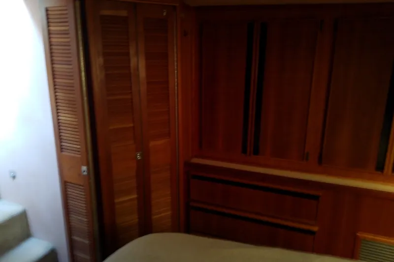 Slide: The Image of 1989 Sea Ray 440 Aft Cabin interior with wooden cabinetry and closet. - 47