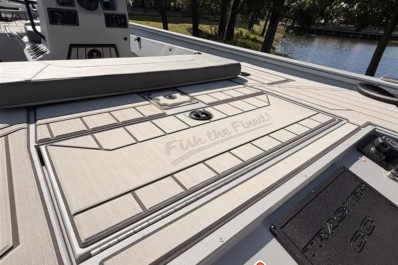 Slide: The Image of 2027 Tracker Bass Tracker 175 CC boat deck with "Fish the Finest" inscription, near a serene lake. - 20