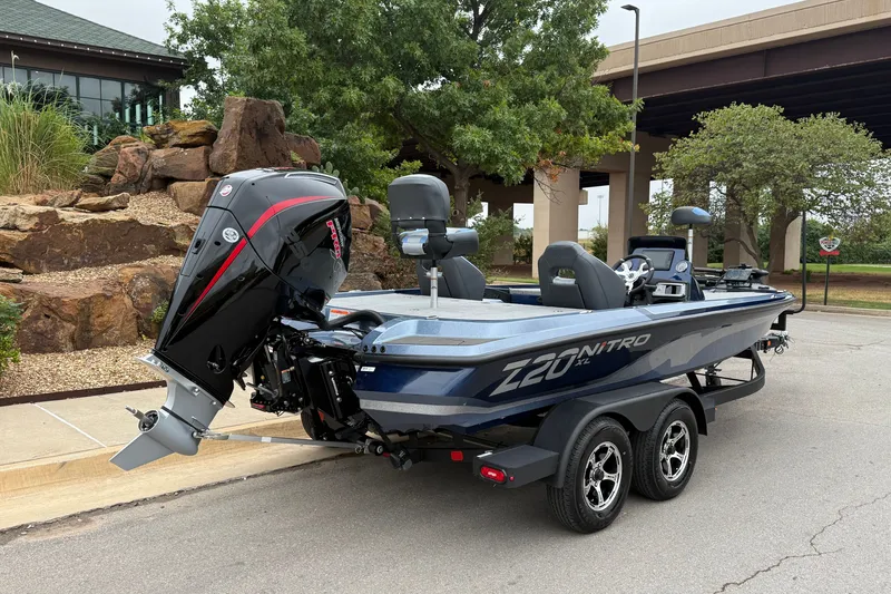 Slide: The Image of 2027 Nitro Z20 XL Pro boat on trailer, parked outdoors near rocks and trees. - 12