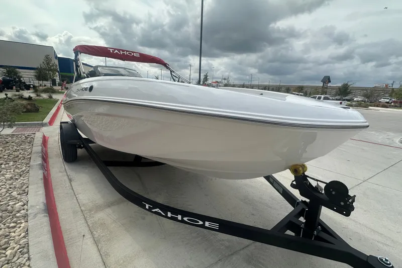 The Image of 2027 Tahoe T18 boat on trailer, parked outdoors under cloudy sky. - 0