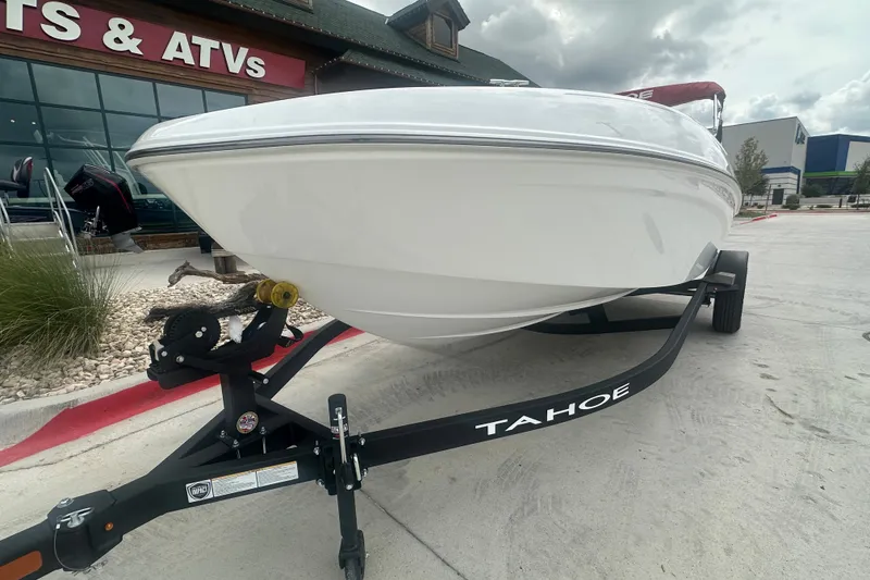 Slide: The Image of 2027 Tahoe T18 boat on trailer outside sports store, cloudy sky background. - 3