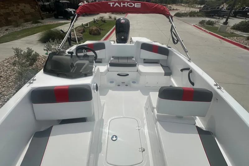 Slide: The Image of 2027 Tahoe T18 boat interior with red and gray seating, steering wheel, and canopy. - 16