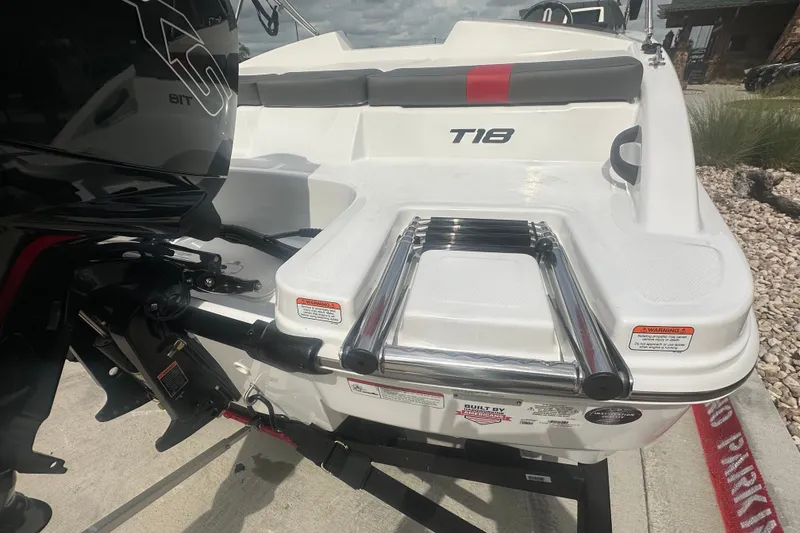 Slide: The Image of 2027 Tahoe T18 boat with ladder and motor, docked on a sunny day. - 6