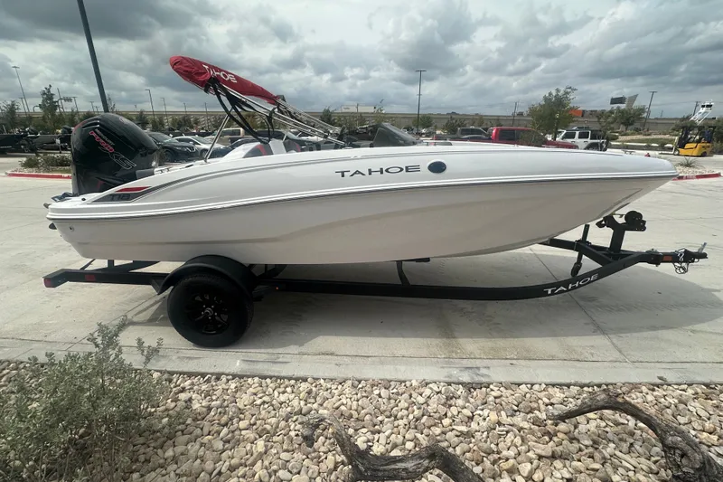 Slide: The Image of 2027 Tahoe T18 boat on trailer, parked outdoors under cloudy sky. - 4
