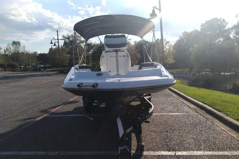 Slide: The Image of 2027 Tahoe 2150 CC boat on trailer in sunny parking lot. - 2