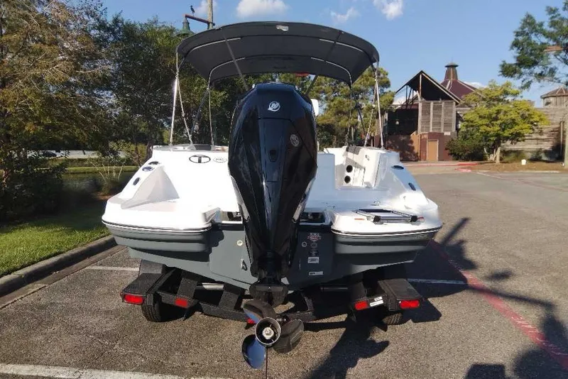 Slide: The Image of 2027 Tahoe 2150 CC boat with outboard motor on trailer, parked outdoors. - 5