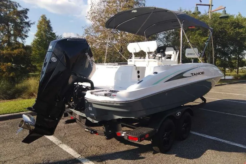Slide: The Image of 2027 Tahoe 2150 CC boat on trailer, parked outdoors with canopy and powerful outboard motor. - 4