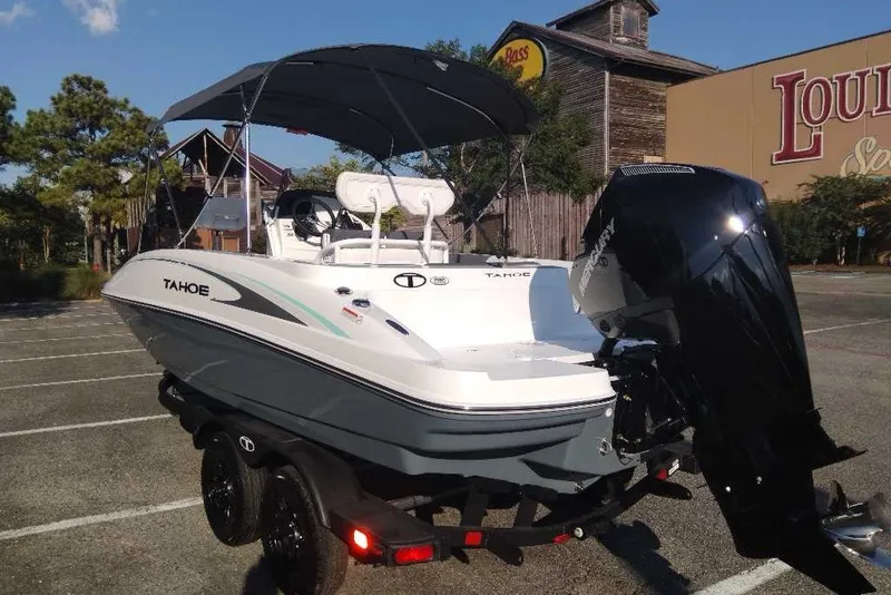 Slide: The Image of 2027 Tahoe 2150 CC boat with outboard motor in a parking lot. - 6