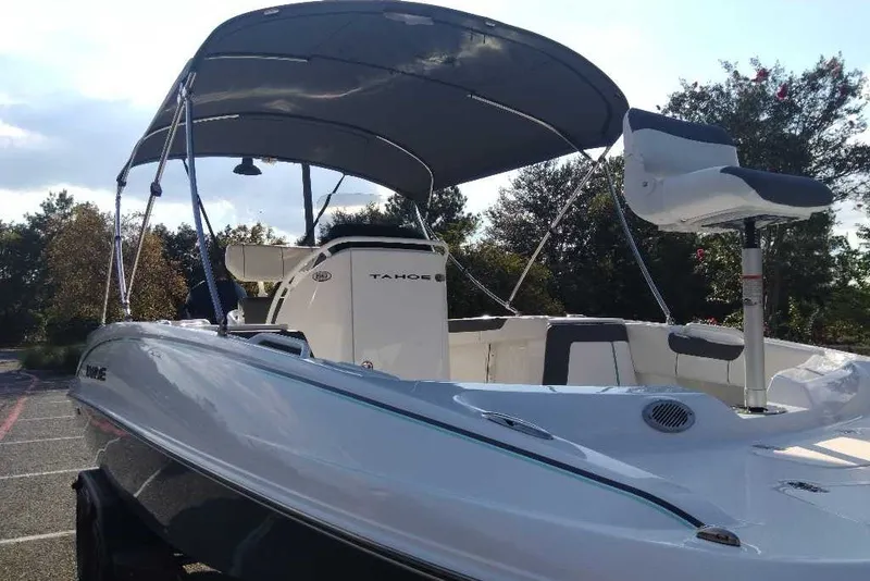 Slide: The Image of 2027 Tahoe 2150 CC boat with canopy, parked outdoors, showcasing sleek design. - 3
