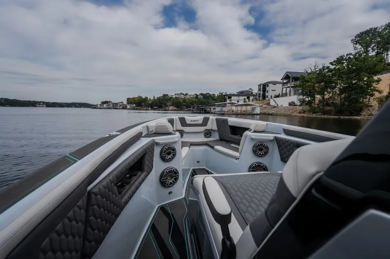 Slide: The Image of Luxurious 2025 AMP 333 CC boat interior with modern seating, speakers, and scenic waterfront view. - 18