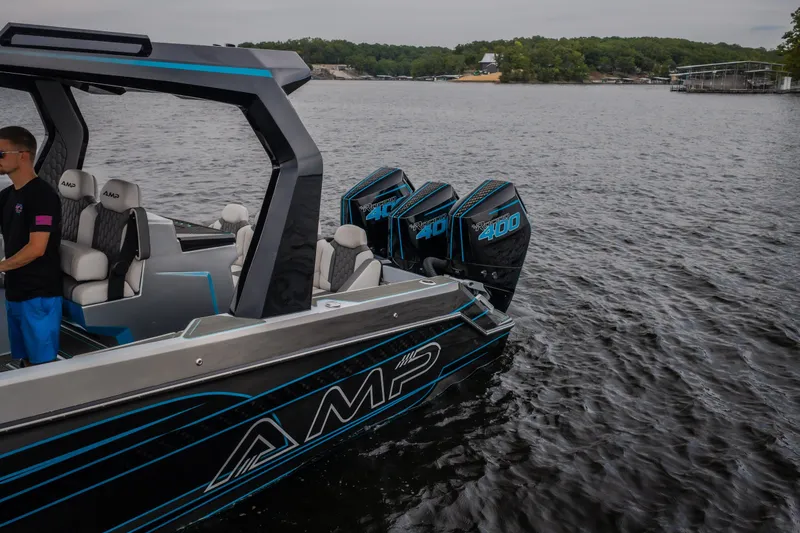 Slide: The Image of 2025 AMP 333 CC boat with triple outboard motors on a lake. - 69