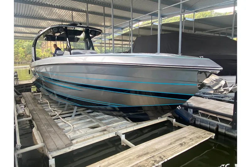 Slide: The Image of 2025 AMP 333 CC boat docked under a metal canopy, showcasing sleek design. - 9