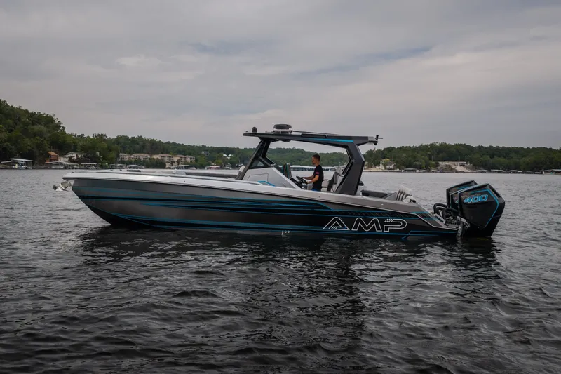 The Image of 2025 AMP 333 CC boat on a lake, featuring sleek design and powerful engine. - 2