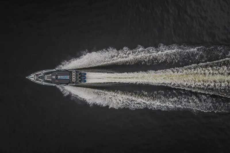Slide: The Image of Aerial view of 2025 AMP 333 CC boat speeding on water, creating dynamic wake patterns. - 76