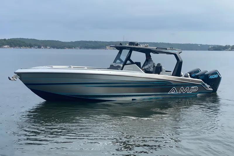 The Image of 2025 AMP 333 CC boat on calm lake waters, showcasing sleek design and powerful engines. - 1