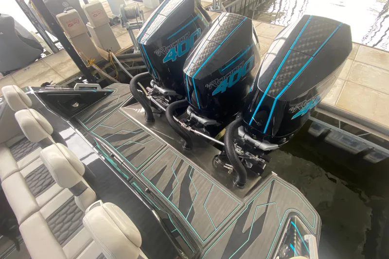 Slide: The Image of 2025 AMP 333 CC boat with triple Racing 400 engines, docked with luxury seating. - 13