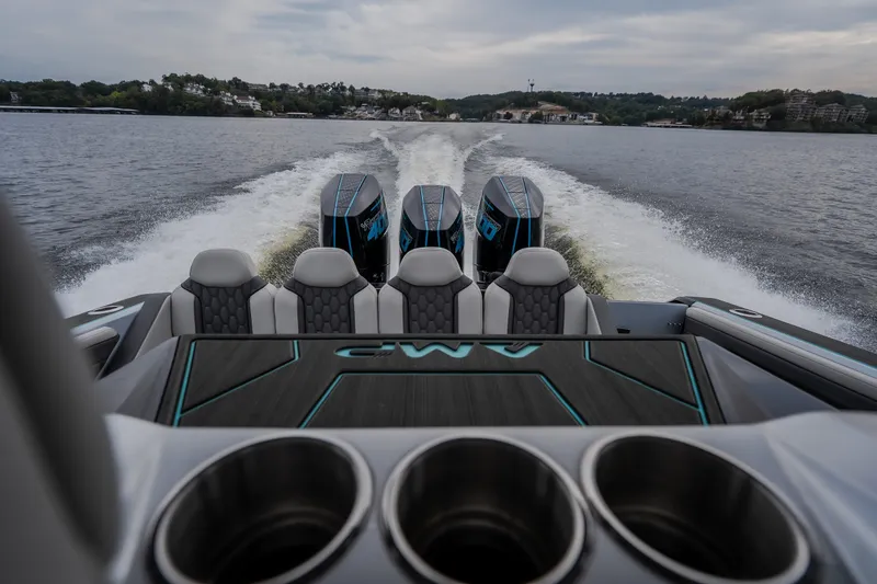 Slide: The Image of 2025 AMP 333 CC boat with powerful engines cruising on a scenic lake. - 16