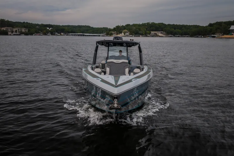 Slide: The Image of 2025 AMP 333 CC boat cruising on a serene lake under a cloudy sky. - 67