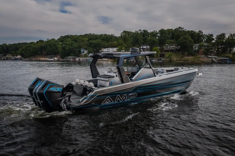 Slide: The Image of 2025 AMP 333 CC boat cruising on a lake with twin 400 engines. - 65