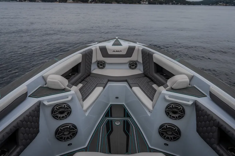 Slide: The Image of Luxurious interior of 2025 AMP 333 CC boat with stylish seating and speakers on calm water. - 27