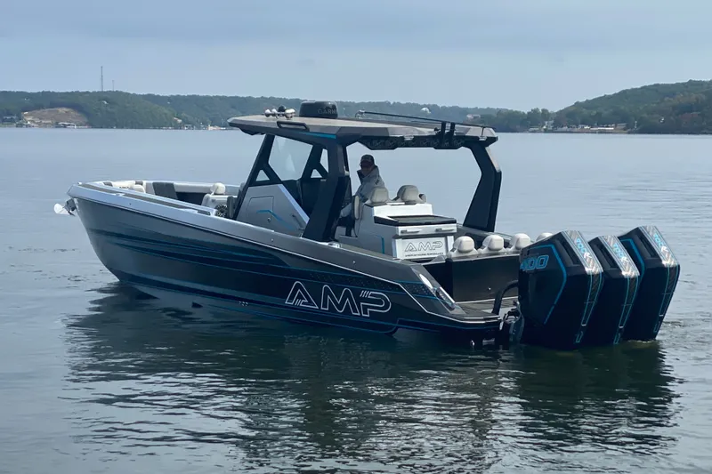 Slide: The Image of 2025 AMP 333 CC boat with triple outboard engines on a calm lake. - 3