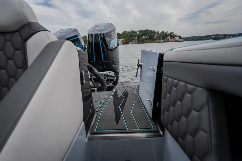 Slide: The Image of 2025 AMP 333 CC boat interior with twin engines on a lake. - 60