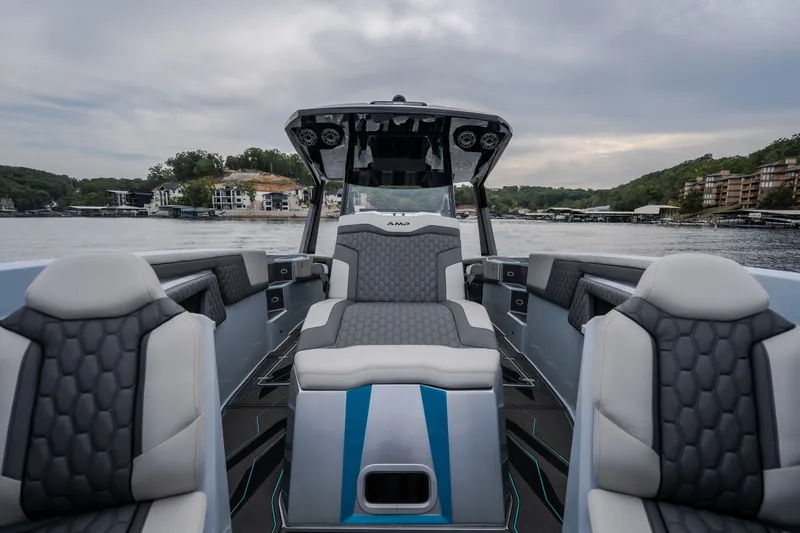 Slide: The Image of Luxurious 2025 AMP 333 CC boat interior with modern seating on a scenic lake. - 26